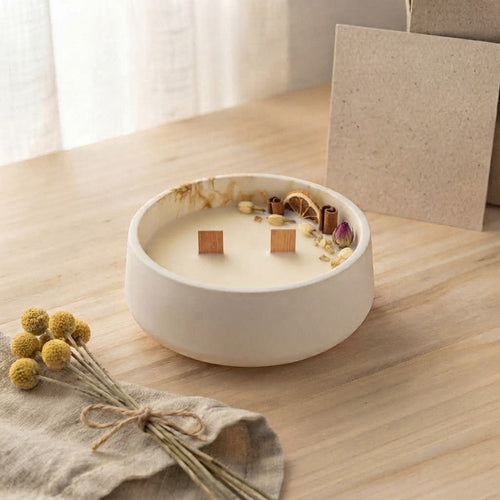 Vela Hogar en cuenco bajo blanco con veta ocre y dos mechas de madera, decorada con canela, naranja seca y flores